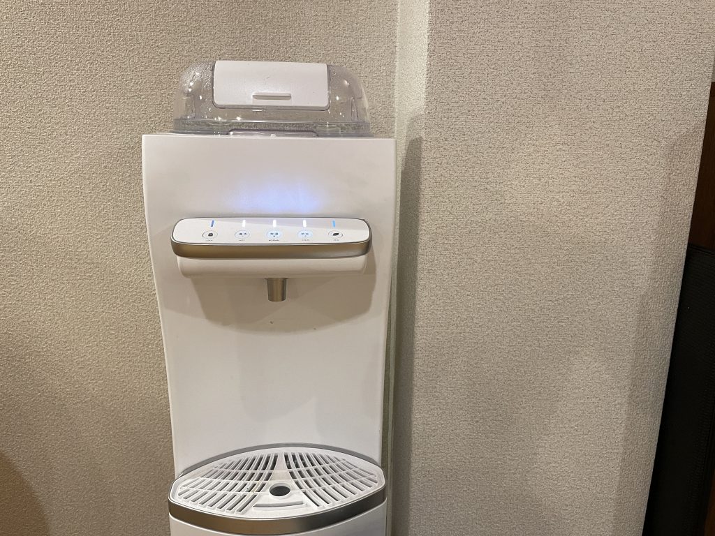 ウォーターサーバーで温浴用のお湯を準備している場面 